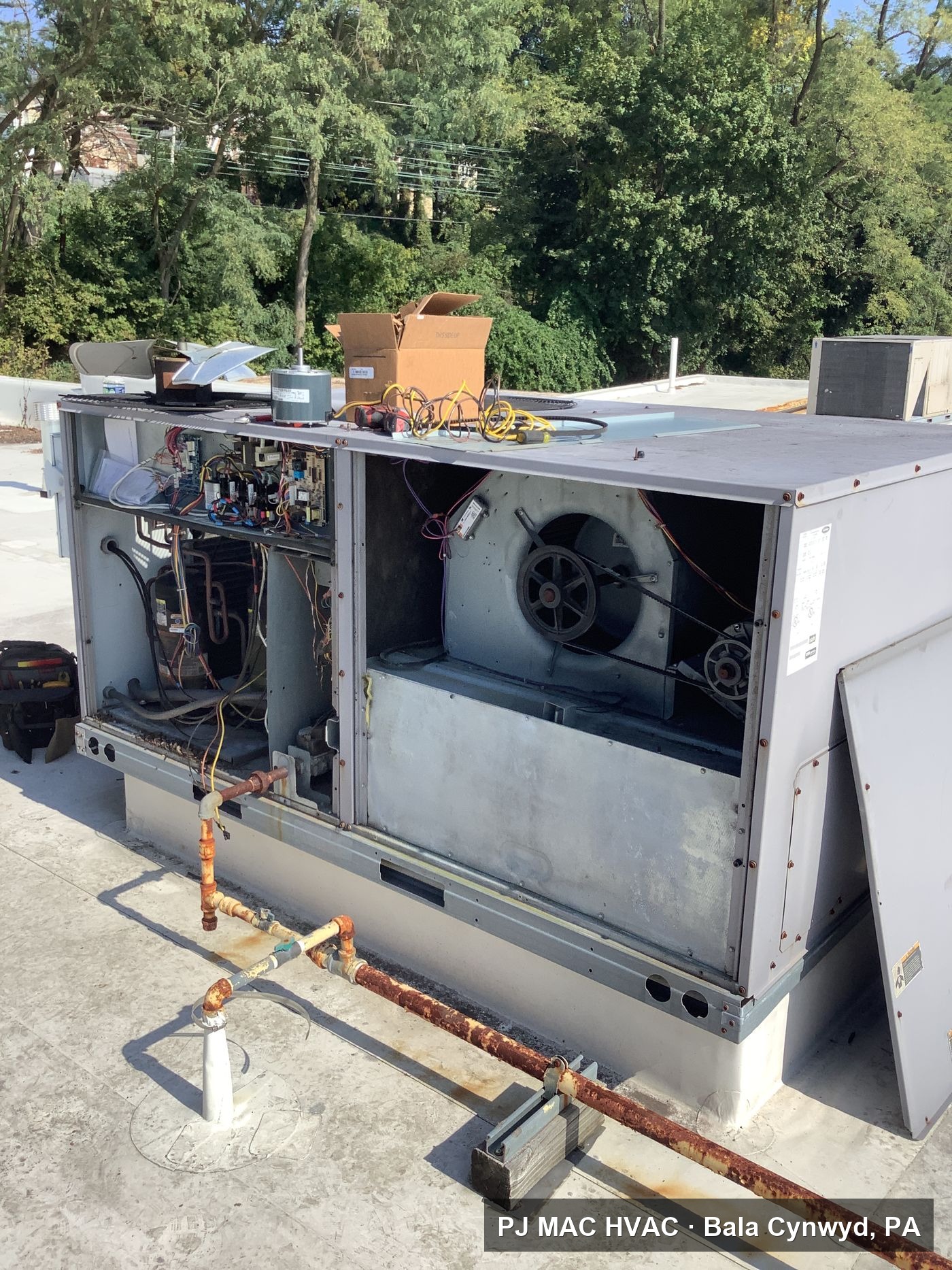 PJ MAC HVAC opens up a commercial rooftop unit to service the blower and control section.