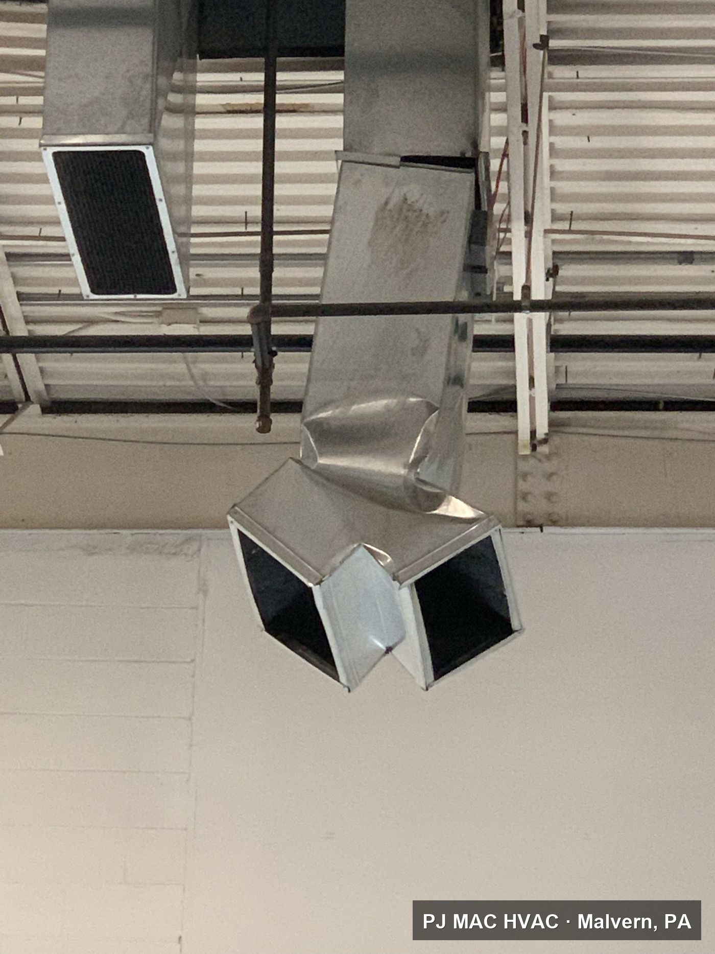 Custom sheet-metal ductwork installed by PJ MAC HVAC under the exposed ceiling of a commercial space.