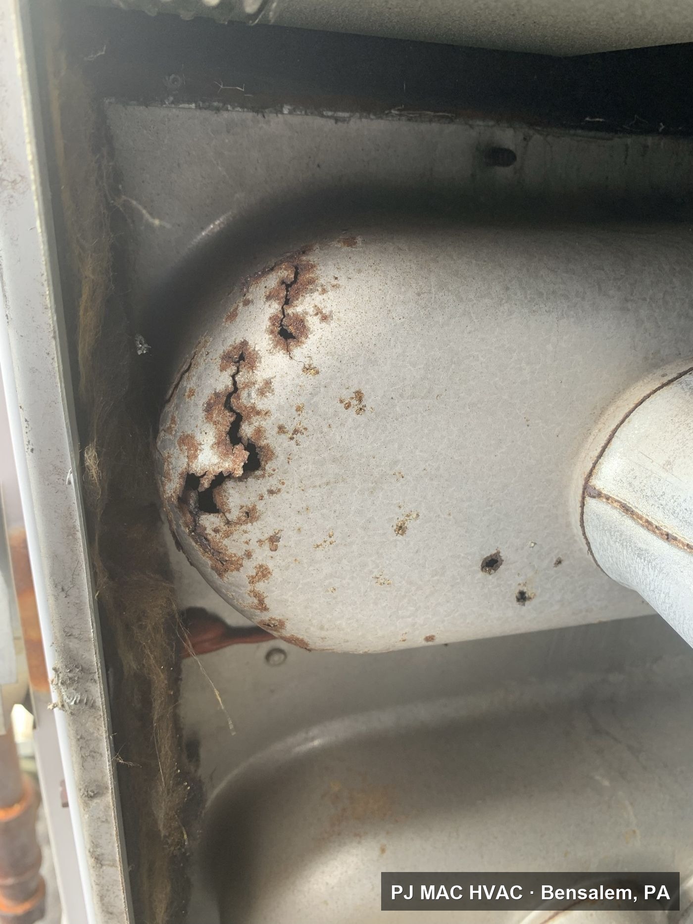 A rusted and cracked furnace heat exchanger discovered by PJ MAC HVAC during a heating system inspection.