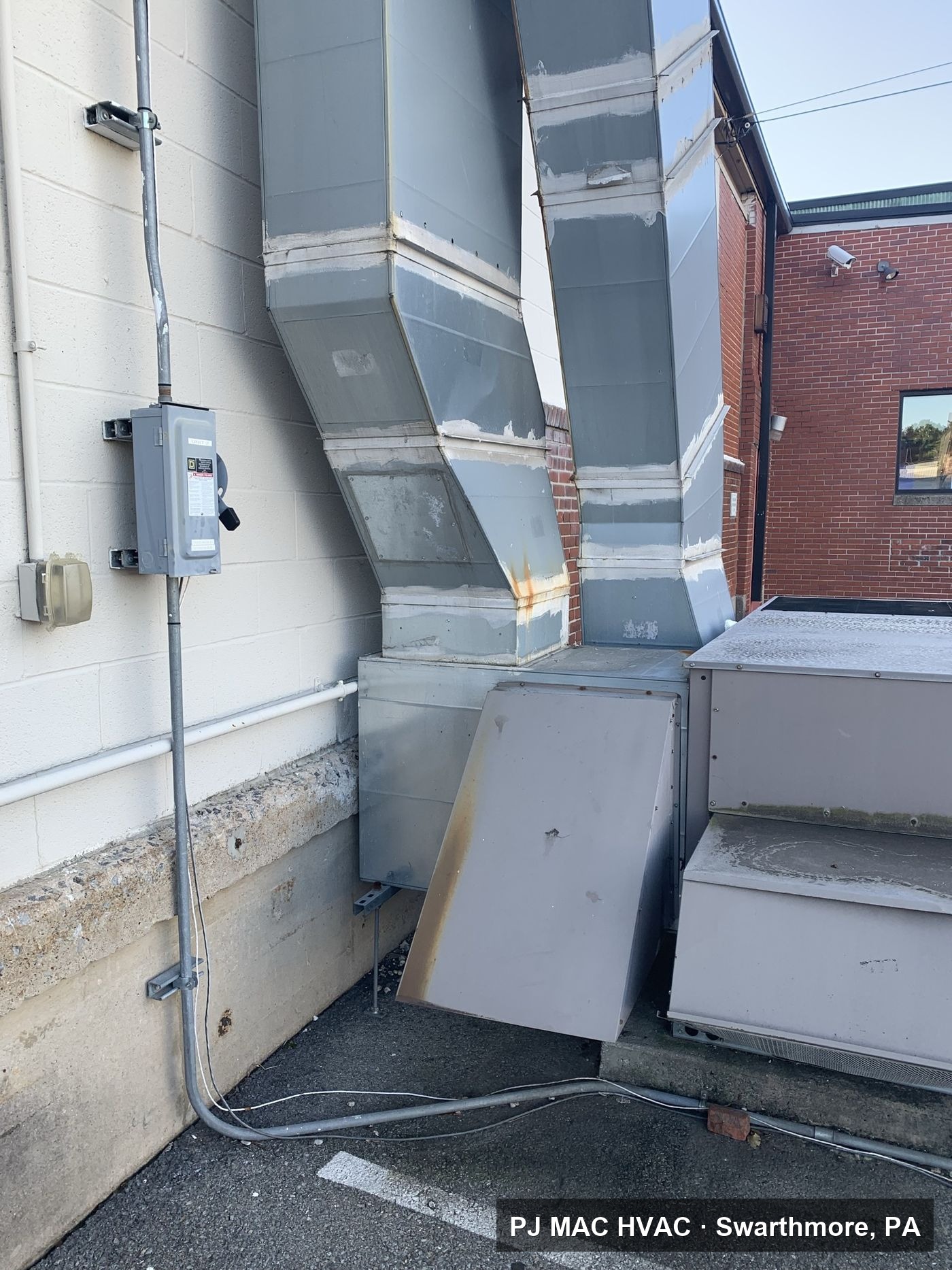 Exterior ductwork run from a packaged HVAC unit into a commercial building, work handled by PJ MAC HVAC.