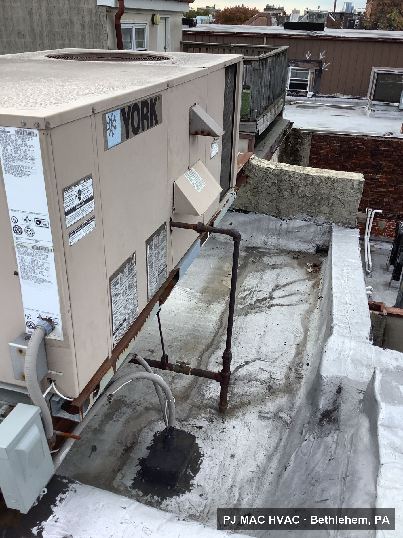 A York packaged rooftop unit installed by PJ MAC HVAC on a city rowhouse roof.